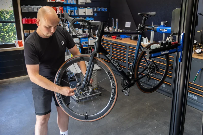 Rik controleert een wiel in de werkplaats in Rekem